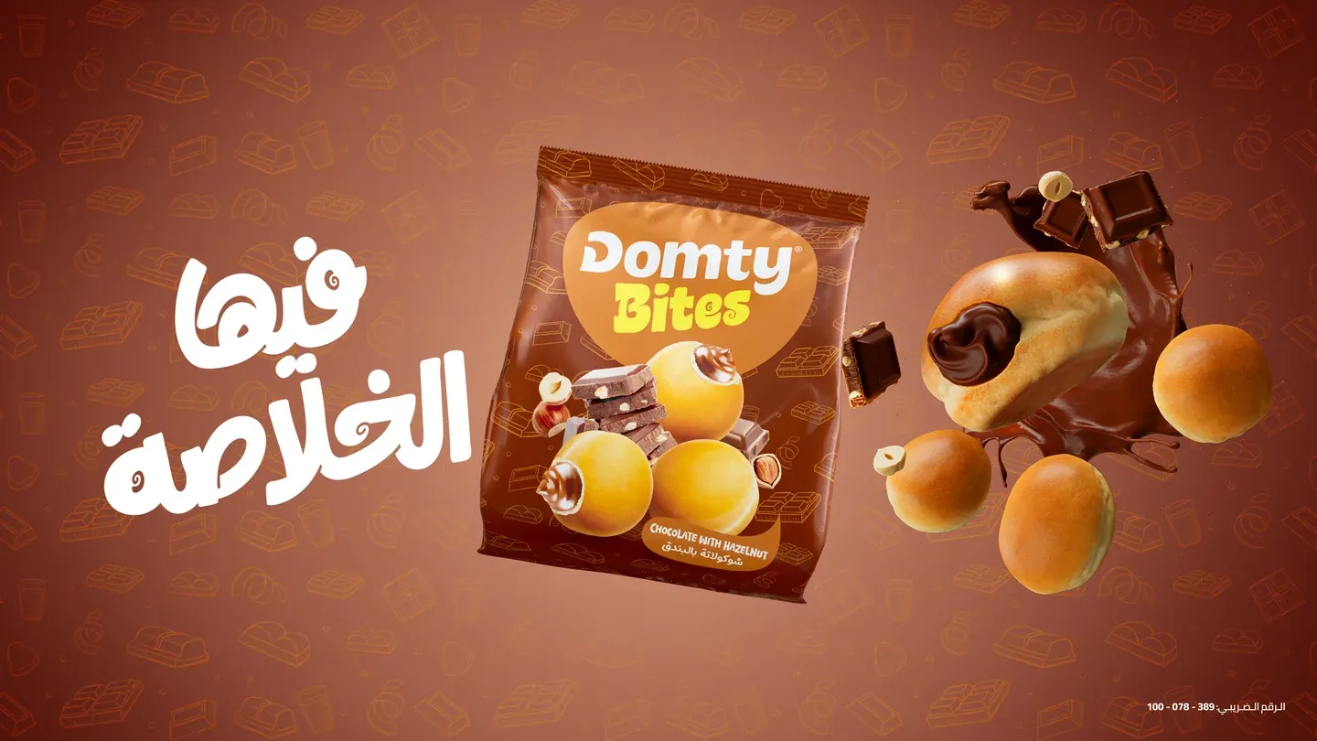Domty Bites chocolate pack surrounded by round snacks and chocolate pieces on brown