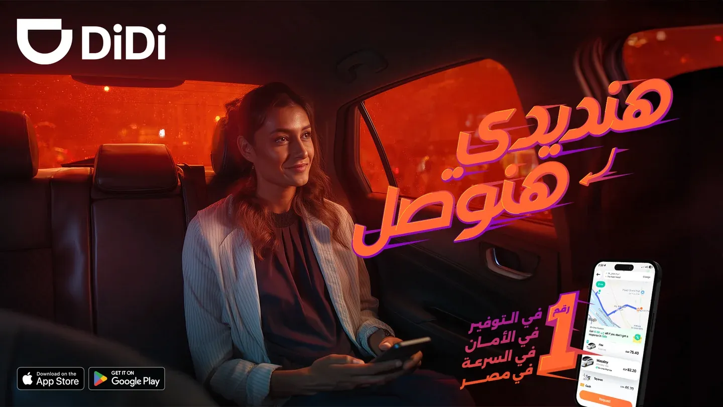 DiDi supplied AI concept with a woman seated in an orange-lit car and Arabic lettering