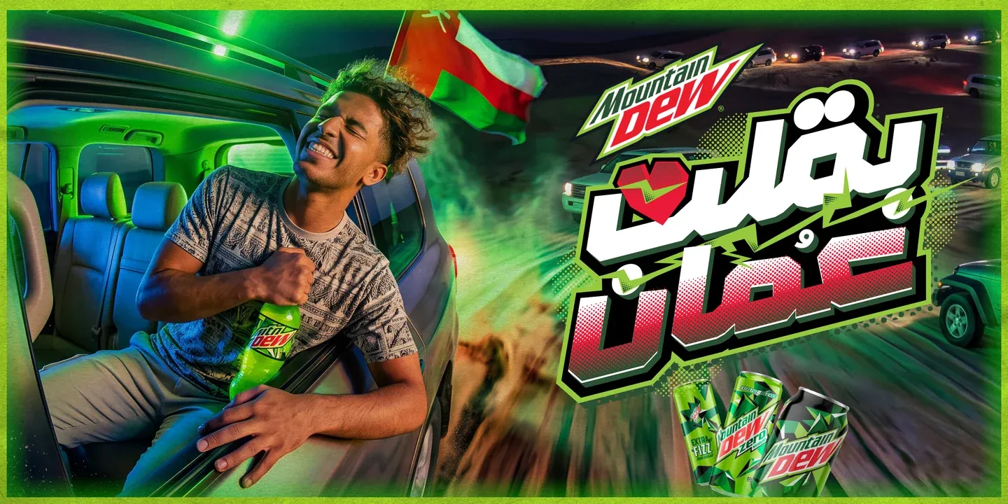 Mountain Dew artwork with a man holding a bottle inside a moving vehicle, an Oman flag and green light trails
