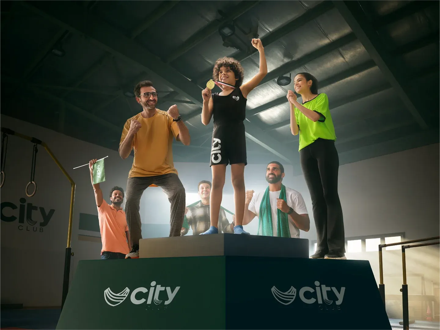 CityClub podium artwork with athletes and a raised trophy inside a sports hall