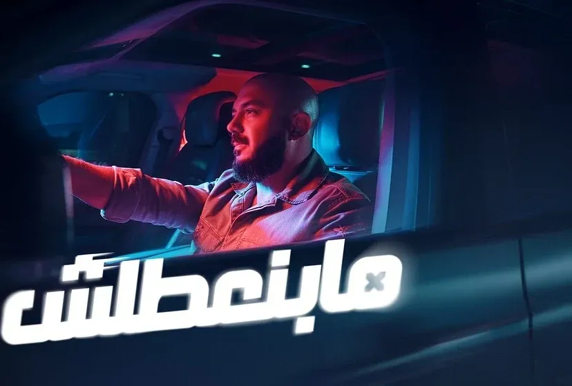 CPC campaign with a man driving at night in red and blue light and a white Arabic headline