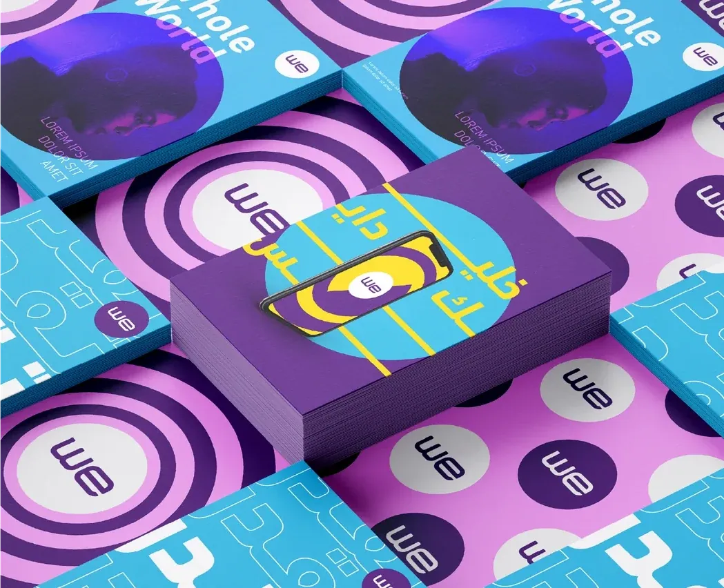 WE branded products and packaging with purple, pink and cyan geometric patterns